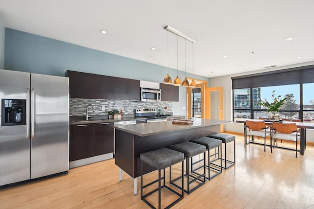 3104 Lake St Unit 202, Minneapolis, MN 55416 - kitchen featuring stainless steel appliances, a sink, modern cabinets, decorative backsplash, and a kitchen bar