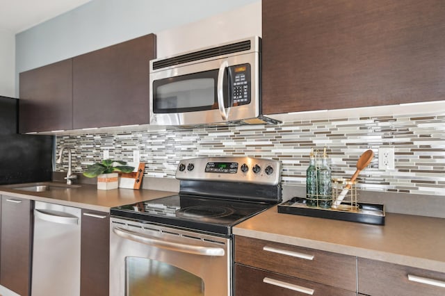 3104 Lake St Unit 202, Minneapolis, MN 55416 - kitchen with stainless steel appliances, decorative backsplash, a sink, and dark brown cabinetry