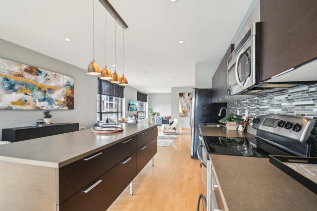 3104 Lake St Unit 202, Minneapolis, MN 55416 - kitchen with stainless steel appliances, modern cabinets, decorative backsplash, hanging light fixtures, and light wood finished floors