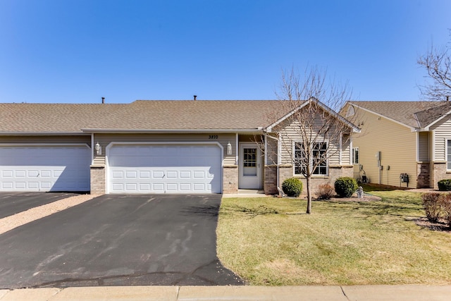 ranch-style home with driveway, a front lawn, a garage, brick siding, and roof with shingles