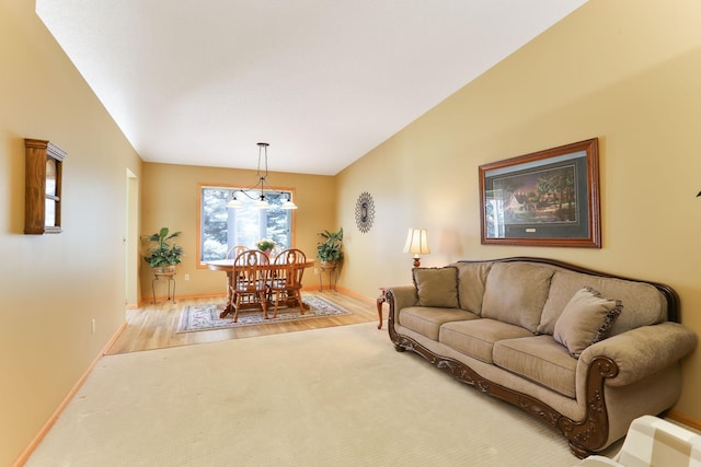 living room featuring a chandelier, baseboards, wood finished floors, and carpet flooring