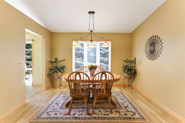 dining room with light wood-type flooring and baseboards
