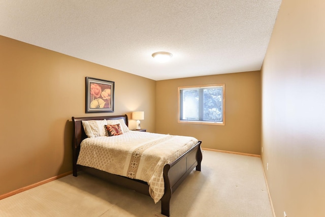 bedroom featuring light colored carpet, baseboards, and a textured ceiling