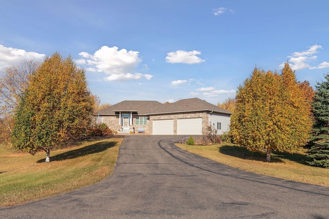 view of front facade with aphalt driveway, a garage, and a front lawn