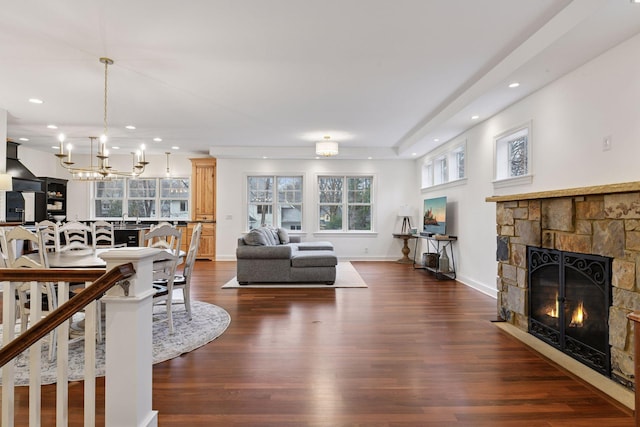 18975 Highland Ave, Deephaven, MN 55391 - living area with a fireplace, a chandelier, dark wood-style floors, recessed lighting, and plenty of natural light