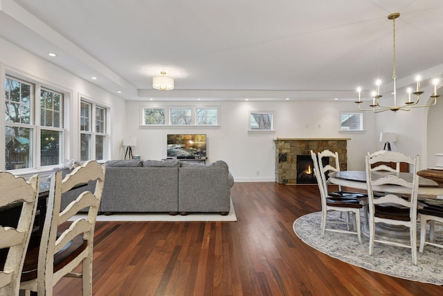18975 Highland Ave, Deephaven, MN 55391 - dining space featuring wood finished floors, a chandelier, baseboards, and a fireplace