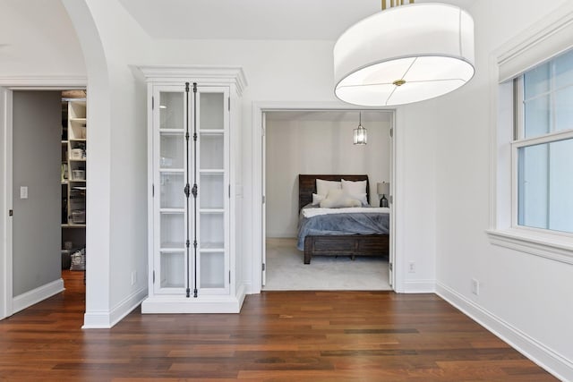 18975 Highland Ave, Deephaven, MN 55391 - bedroom with wood finished floors, arched walkways, and baseboards