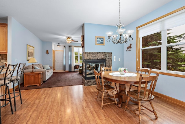 11102 16th St NE, Saint Michael, MN 55376 - dining room with a fireplace, light wood-style flooring, a ceiling fan, and a chandelier