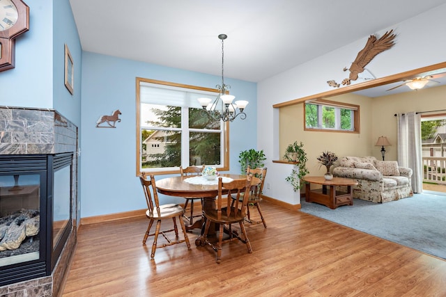 11102 16th St NE, Saint Michael, MN 55376 - dining room with light wood finished floors, a multi sided fireplace, a chandelier, and a ceiling fan