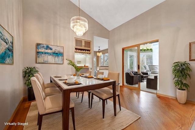780 Virginia Shores Cir, Excelsior, MN 55331 - dining space featuring high vaulted ceiling, light wood-type flooring, a chandelier, and baseboards