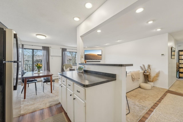 kitchen with dark countertops, freestanding refrigerator, white cabinets, dark wood-style floors, and recessed lighting
