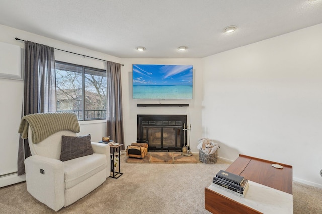 living area with a baseboard heating unit, baseboards, a glass covered fireplace, and carpet floors