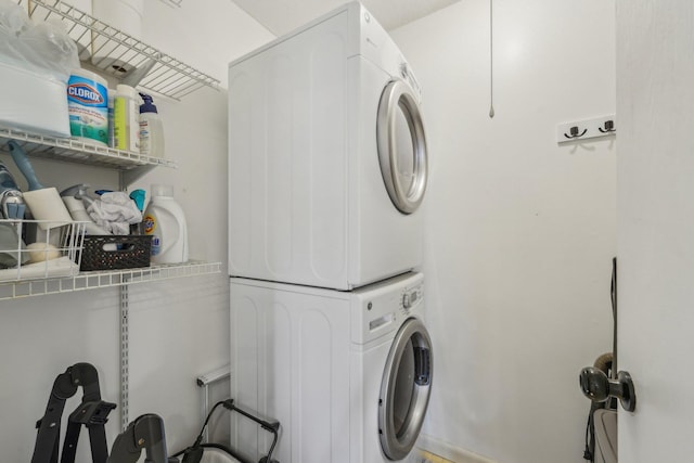clothes washing area featuring stacked washer / drying machine and laundry area