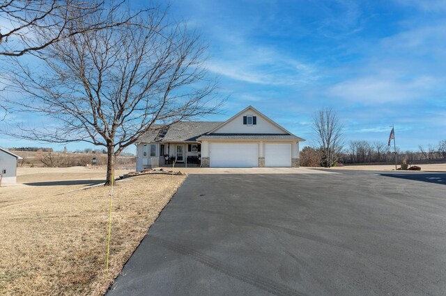 26141 Jonquil Ave, New Market Twp, MN 55020 - traditional-style house with stone siding, asphalt driveway, an attached garage, and covered porch