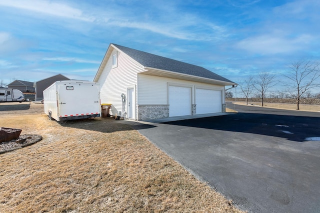 26141 Jonquil Ave, New Market Twp, MN 55020 - view of side of property featuring a garage, an outdoor structure, brick siding, and roof with shingles