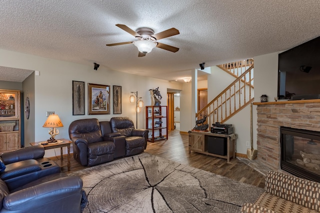 26141 Jonquil Ave, New Market Twp, MN 55020 - living area with a textured ceiling, ceiling fan, wood finished floors, stairway, and a stone fireplace