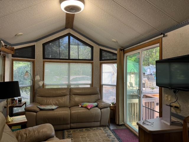 living area with lofted ceiling with beams