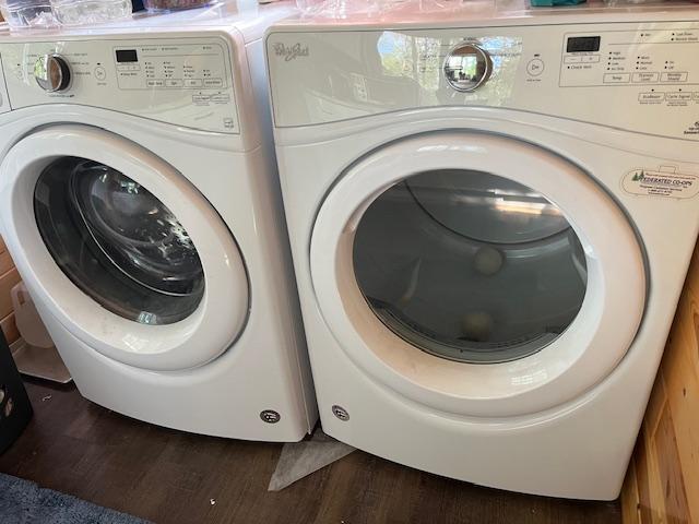washroom with independent washer and dryer, wood finished floors, and laundry area