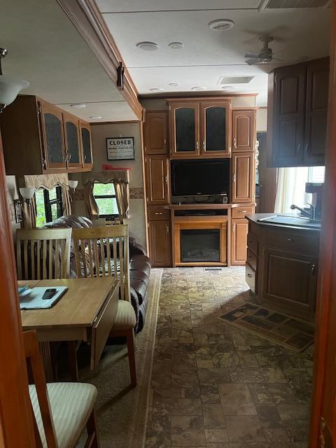 interior space with glass insert cabinets and ceiling fan
