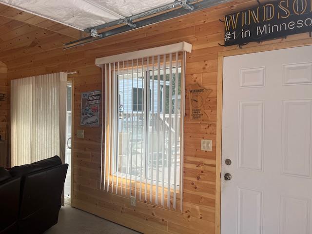 doorway to outside featuring wooden walls