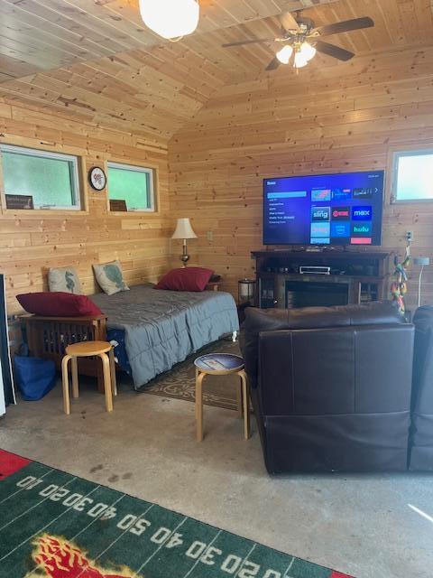 bedroom with wood walls, vaulted ceiling, and wood ceiling