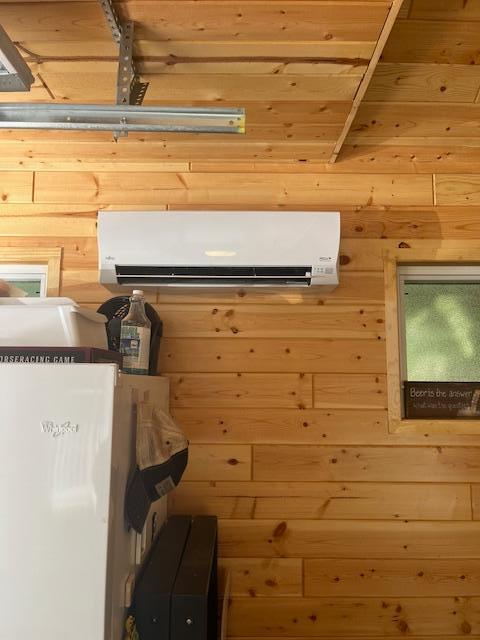 interior space featuring wood walls and an AC wall unit