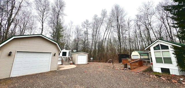 view of side of property with a gambrel roof, an outdoor structure, and a garage