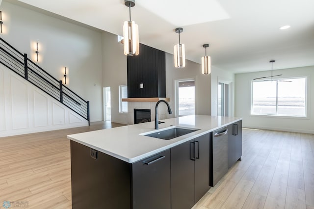 8030 59th St S, Horace, ND 58047 - kitchen featuring a sink, stainless steel dishwasher, a center island with sink, pendant lighting, and light wood-style flooring