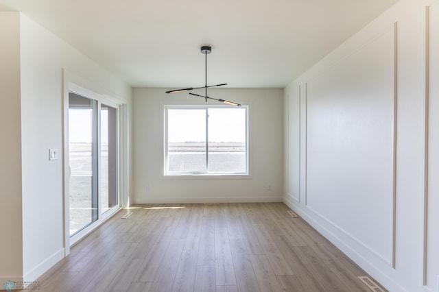 8030 59th St S, Horace, ND 58047 - unfurnished dining area featuring a chandelier, light wood finished floors, and baseboards