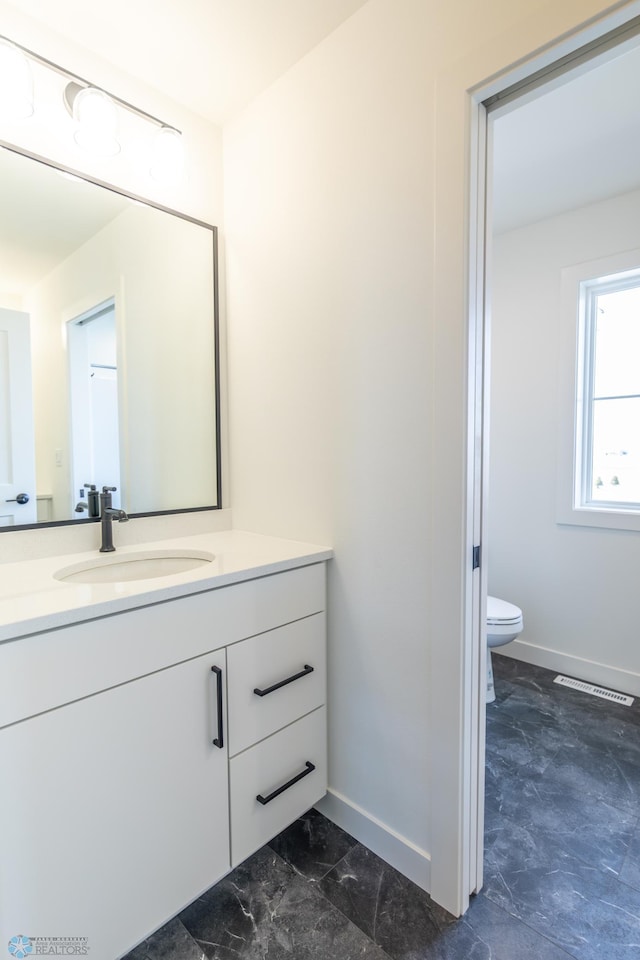 8030 59th St S, Horace, ND 58047 - bathroom with baseboards, toilet, vanity, and marble finish flooring