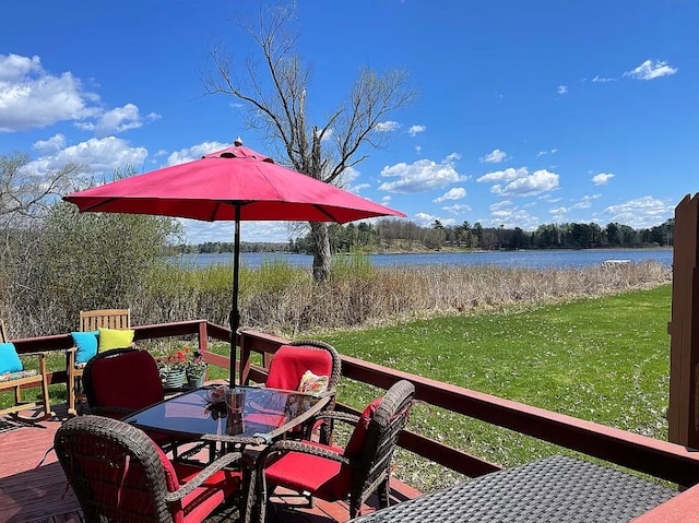 wooden deck with a water view and a lawn