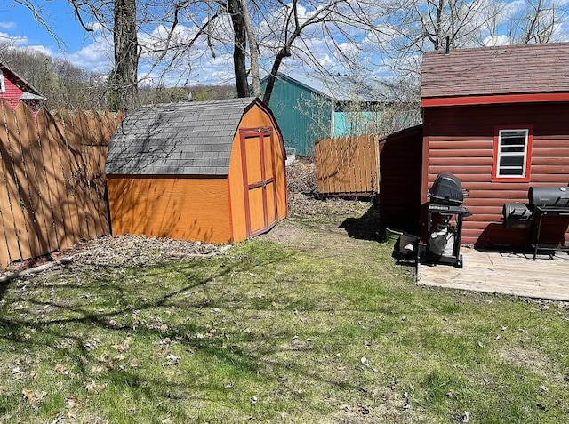 view of yard featuring a storage shed, fence, and an outbuilding