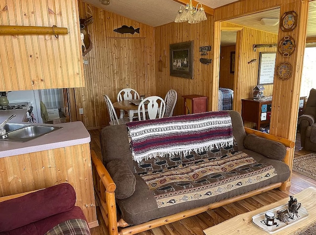 bedroom with a sink, lofted ceiling, wood finished floors, and wood walls