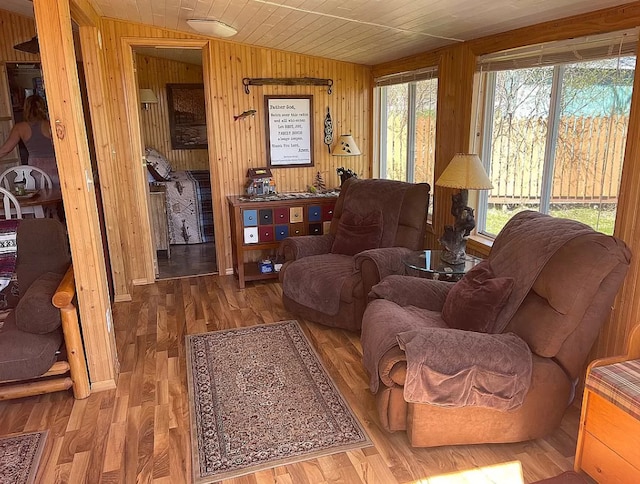 living room with wood ceiling, wooden walls, and wood finished floors