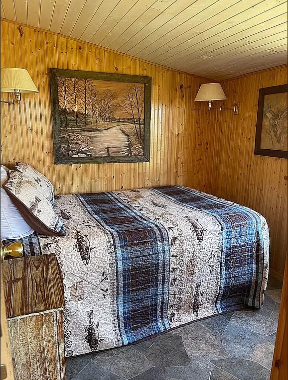 bedroom featuring wood ceiling and wood walls