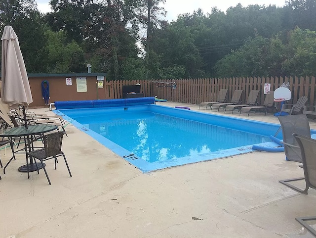 pool with a patio and fence