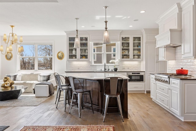 kitchen with a sink, light wood-style floors, a breakfast bar, and stainless steel appliances