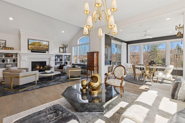 dining space featuring a glass covered fireplace, ceiling fan, recessed lighting, and wood finished floors