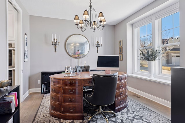 office area with an inviting chandelier, baseboards, and wood finished floors