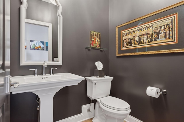 bathroom featuring baseboards and toilet