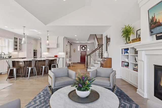 208 Byrondale Ave, Wayzata, MN 55391 - living room with a premium fireplace, light wood-type flooring, lofted ceiling, recessed lighting, and stairway