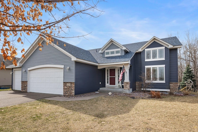 craftsman-style home with a garage, a front yard, driveway, and stone siding