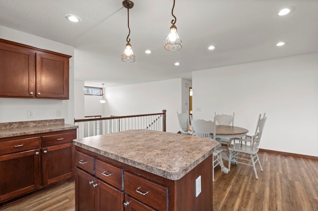 kitchen with recessed lighting, decorative light fixtures, baseboards, dark wood-type flooring, and a kitchen island