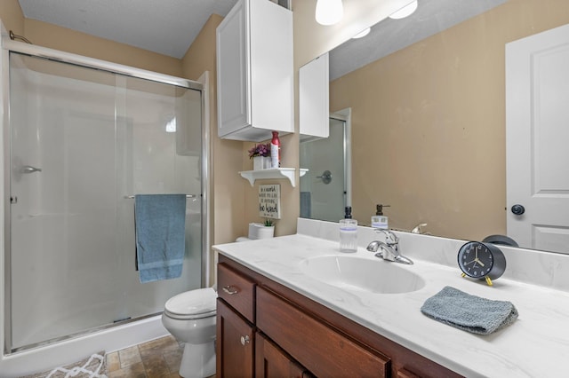 full bath with toilet, stone finish flooring, a shower stall, and vanity