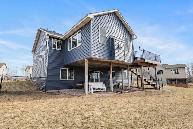 rear view of house featuring a lawn, a patio, stairway, and fence