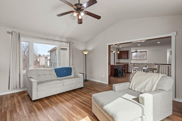 living room with a ceiling fan, baseboards, and lofted ceiling