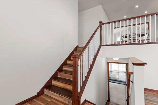 stairway with baseboards, recessed lighting, and wood finished floors