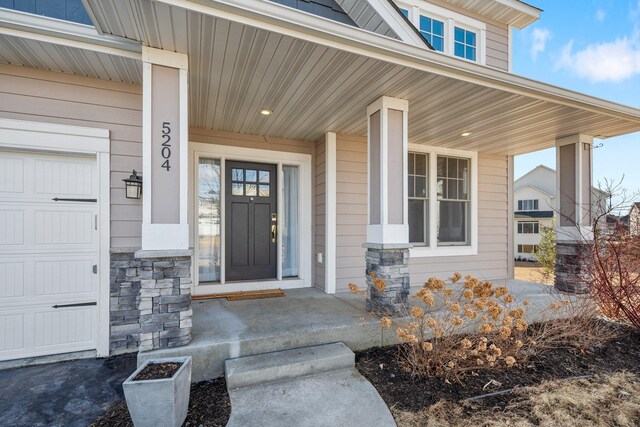 5204 Porchlight, Woodbury, MN 55129 - entrance to property with stone siding, a porch, and a garage