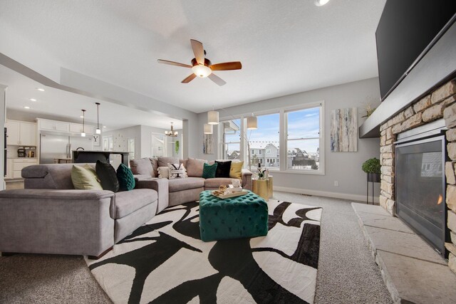5204 Porchlight, Woodbury, MN 55129 - carpeted living area with recessed lighting, baseboards, a stone fireplace, and ceiling fan with notable chandelier