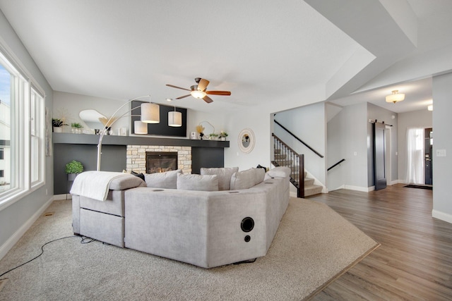 5204 Porchlight, Woodbury, MN 55129 - living area with baseboards, ceiling fan, stairway, a stone fireplace, and wood finished floors